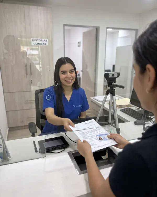 La recepcionista de Azul Médica recibe a un paciente en el mostrador
