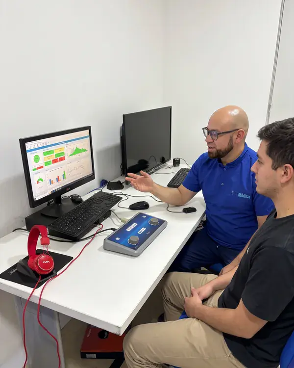 El psicólogo explica la prueba psicosensométrica a un paciente frente al computador