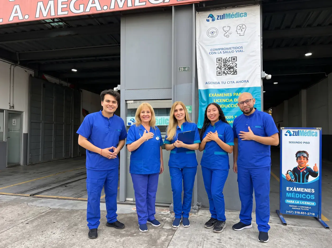 El equipo de Azul Médica en la entrada de la sede, junto al pendón de exámenes médicos
