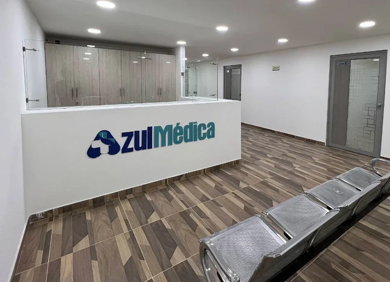Mostrador de recepción de Azul Médica con el logo en la pared, en el segundo piso